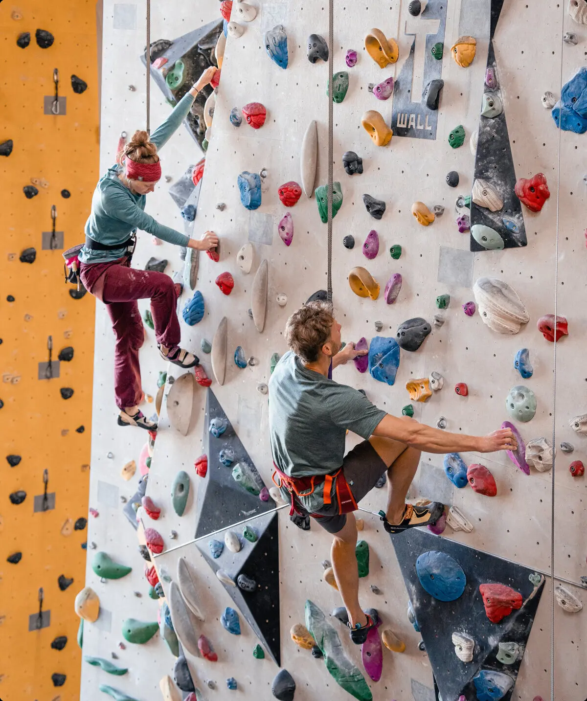 Zwei Personen bouldern nebeneinander an einer Boulderwand | © DAV/Marisa Koch