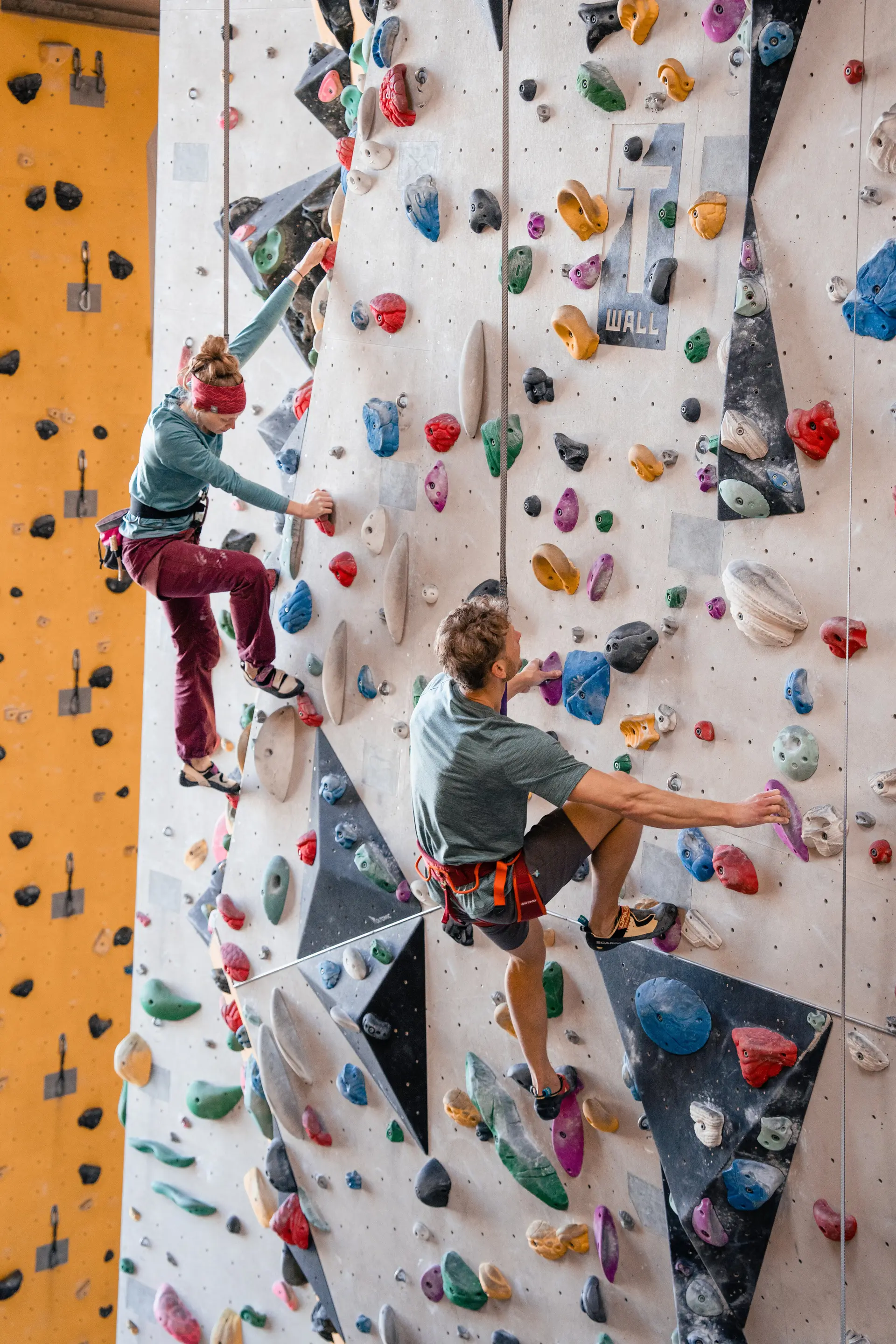 Zwei Personen bouldern nebeneinander an einer Boulderwand | © DAV/Marisa Koch