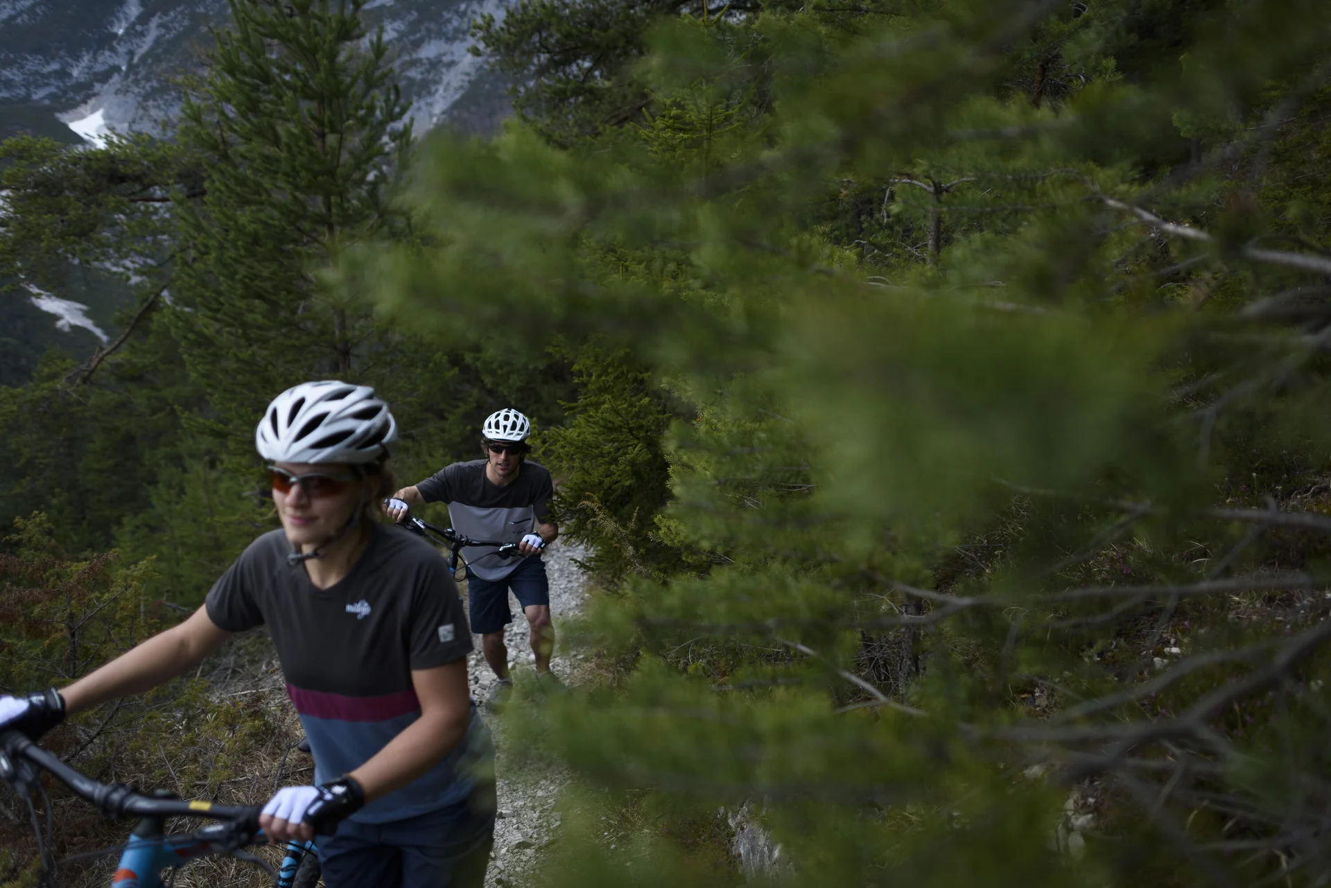 Ein Mountainbiker schiebt sein Rad auf einem Trail in den Bergen. | © DAV/Wolfgang Ehn