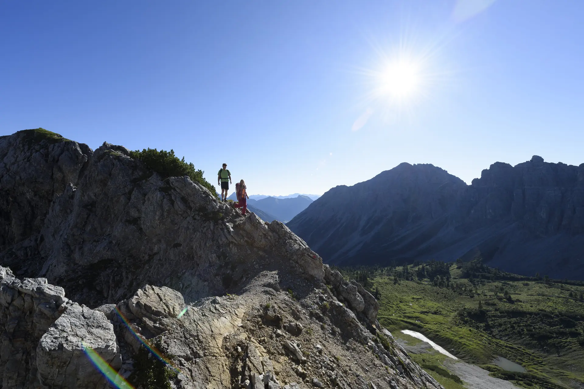 Panoramaaufname von Berggipfeln mit zwei Wanderern | © DAV/Wolfgang Ehn