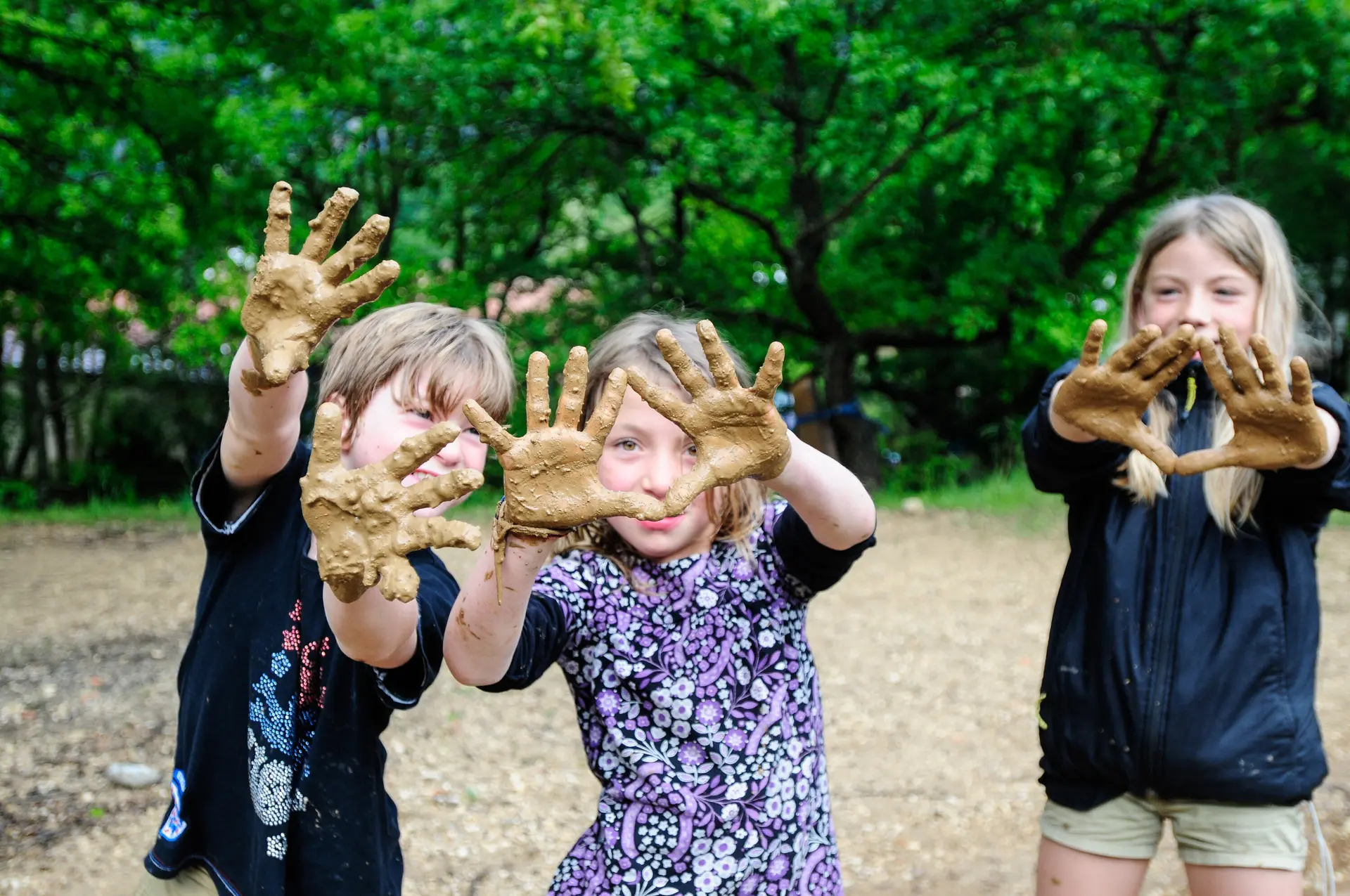 Drei Kinder zeigen vergnügt ihre schmutzigen Hände in die Kamera | © DAV / Birgit Gelder